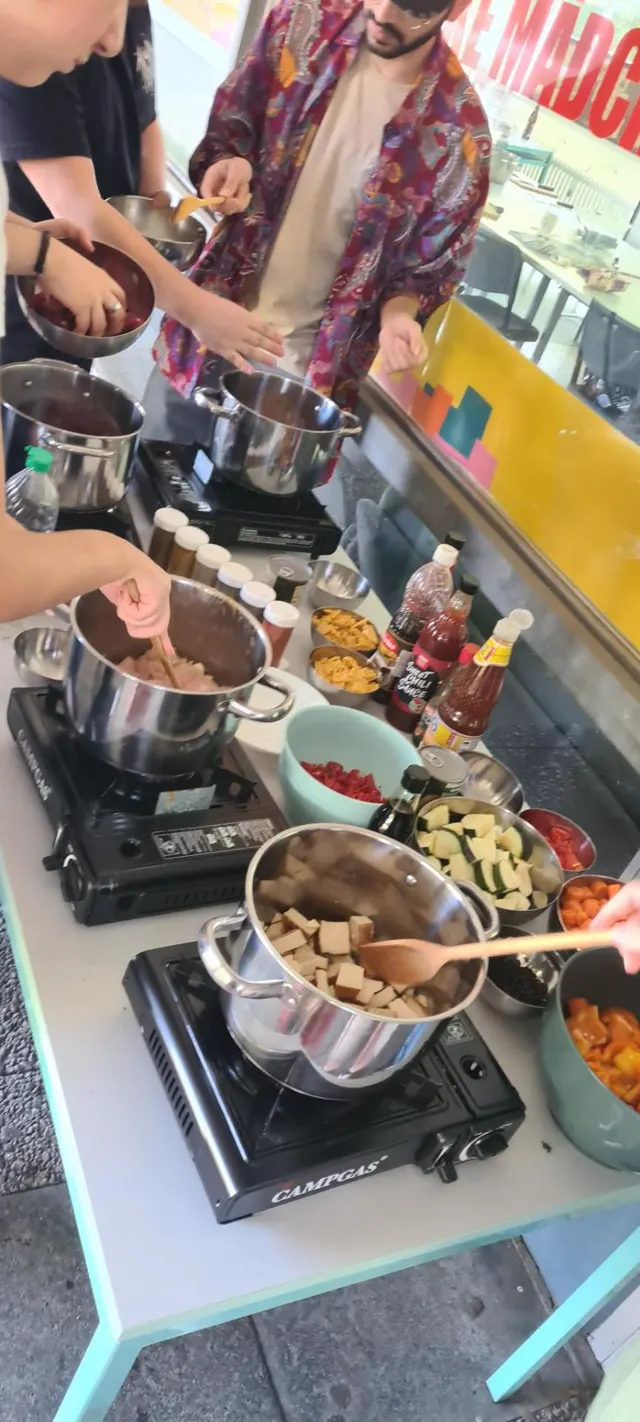 Kochstation mit dampfenden Töpfen, Gewürzflaschen und einem Koch im Kimono