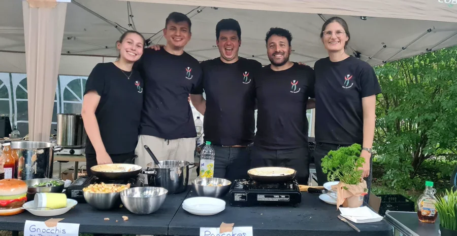 Die Mitkochen-Crew hinter der Kochstation unterm Pavillon