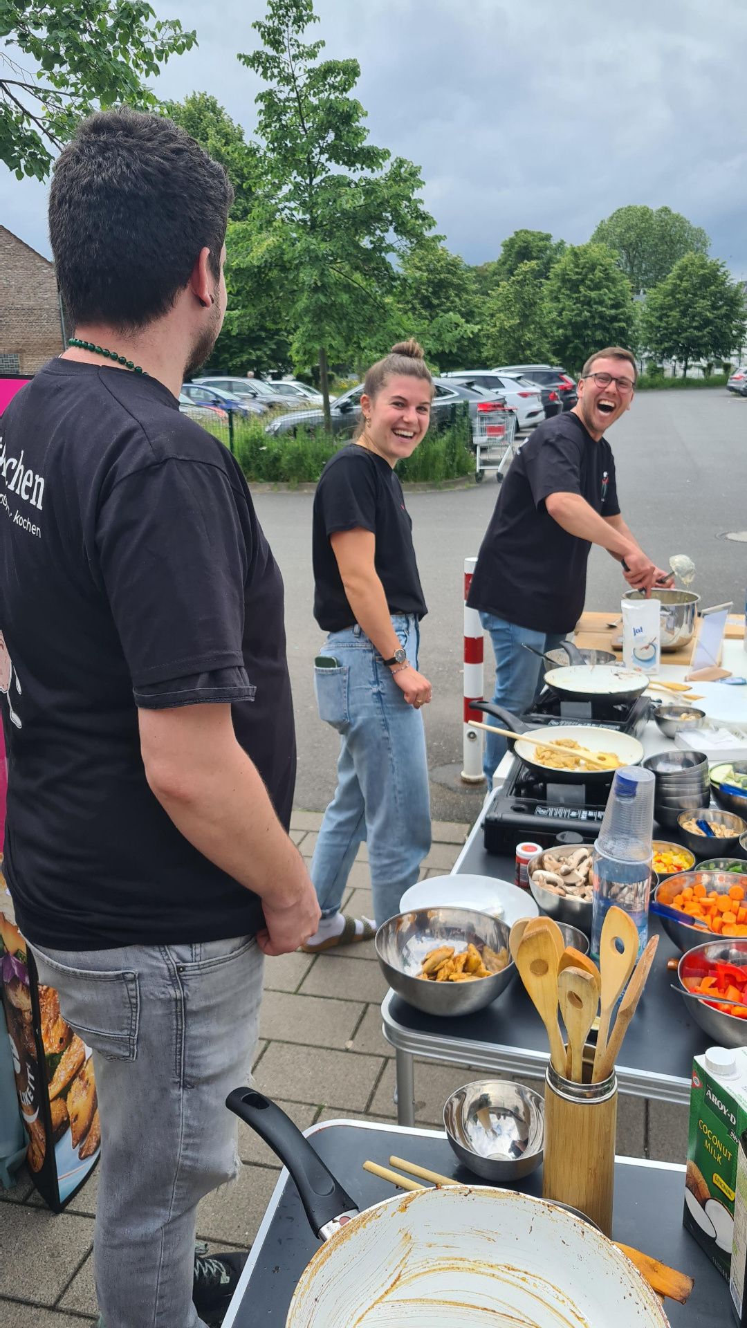 Mitkochen-Crew kocht und lacht gemeinsam an der Kochstation eines Mitkochen-Events in NRW
