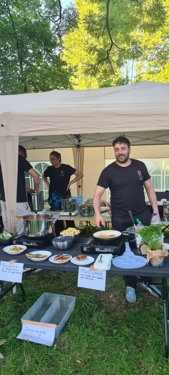 Antonio grinst hinter der Pancake-Station mit handgeschriebenen Menükarten