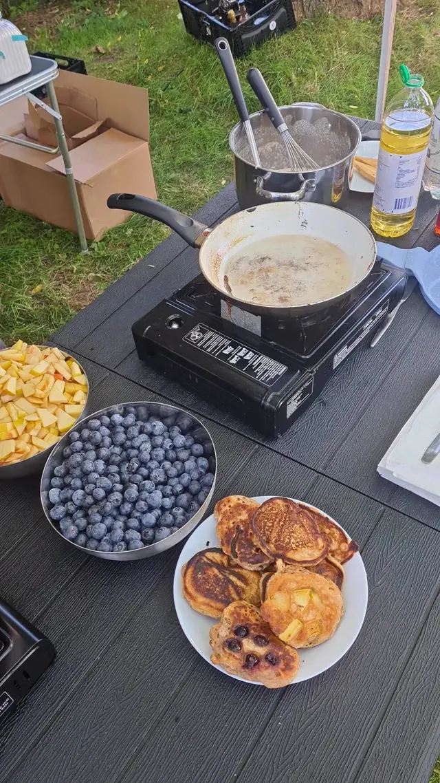 Frisch gebackene Pancakes mit Blaubeeren und Apfelstücken